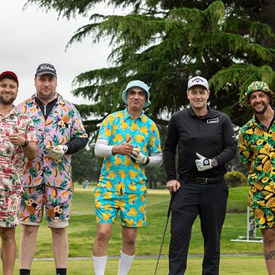 Photo of a dodgeball team, wearing bright active wear, posing enthusiastically to camera.