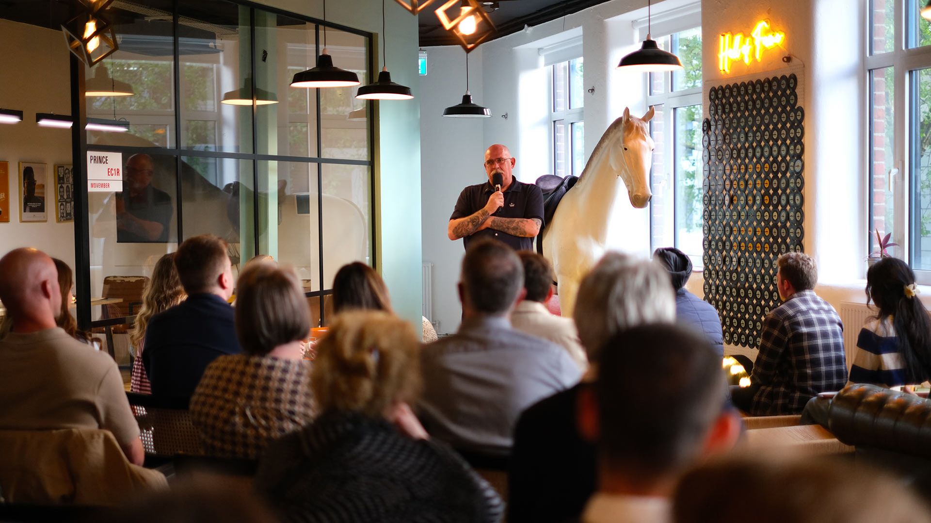 Photo of a middle-aged man addressing a seated audience.