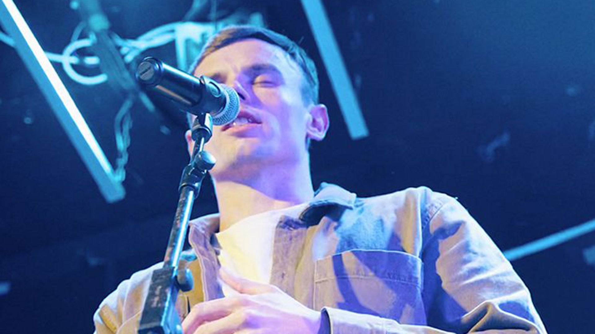 Photo of emotive-looking man reciting on a stage.