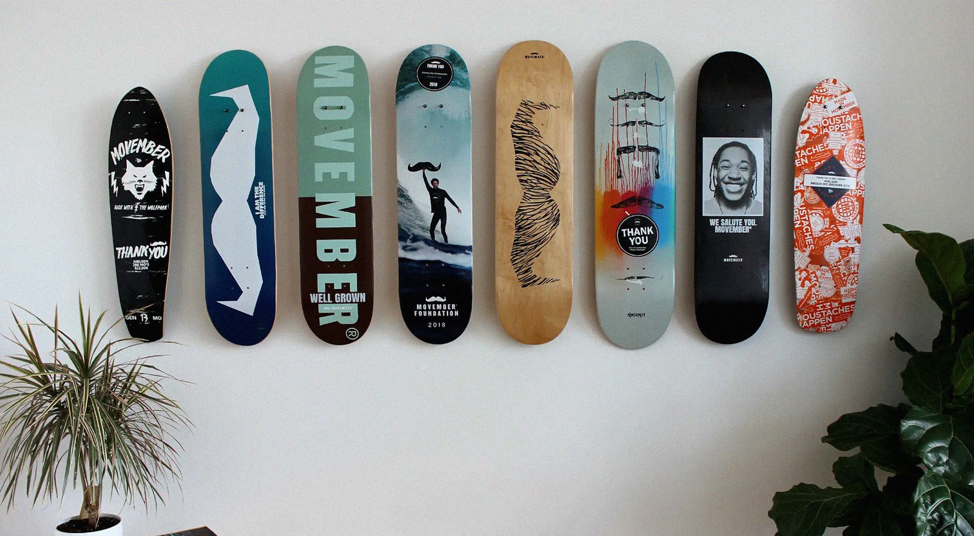 8 colorful skateboard decks adorn the wall of a home office