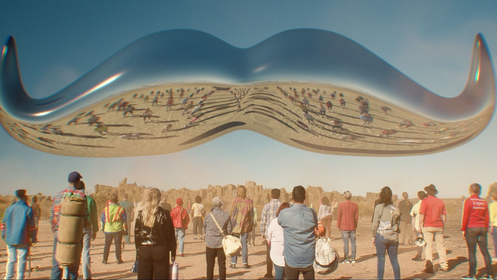 Giant movember moustache logo floating in air as people watch. Taken from campaign advert.