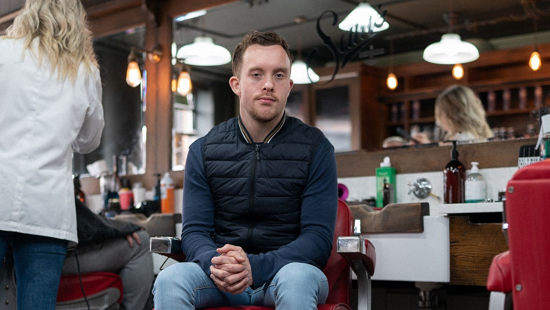 Colm sat in a barber chair facing camera