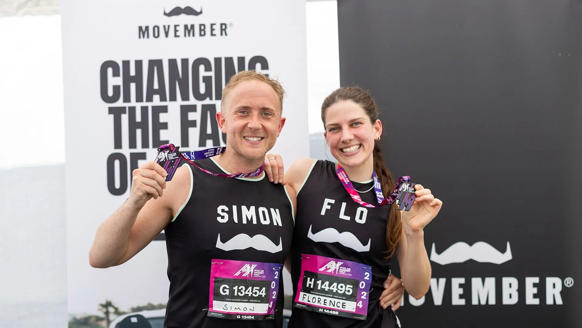 Photo of marathon runners showing off their finisher medals, wearing Movember-branded attire.
