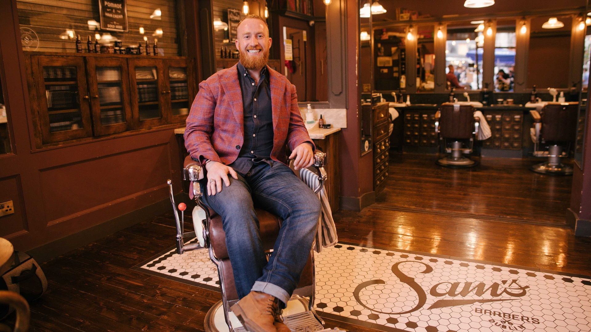 Man sits in barbers chair in barber shop
